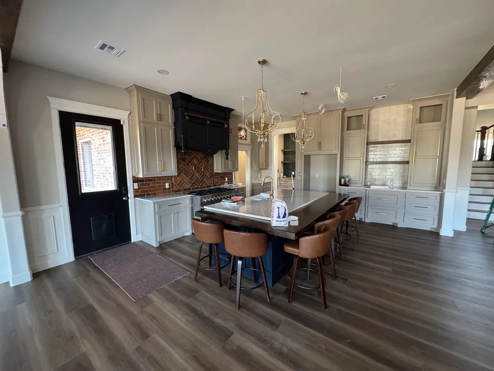 finished custom kitchen remodel with painted cabinetry, brick backsplash and large island